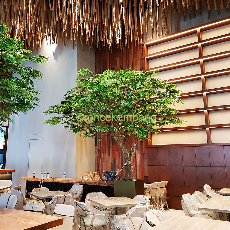 Pohon-pohon artificial yang besar menghadirkan aura taman nan asri di cafe